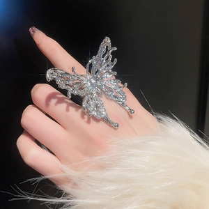 Detailed close-up of a silver butterfly ring featuring liquid metal textures and pearls
