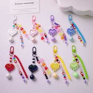 Macro shot of colorful pixel heart keychains with LOVE letter beads and star charms