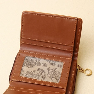 Detailed view of brown trifold wallet showing card slots and golden zipper closure