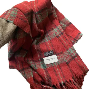 Red and green plaid scarf with fringe tassels made of thick warm winter fabric