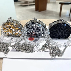 Nahaufnahme von drei funkelnden Pailletten-Minibags mit Silberkette und Perlenriemen