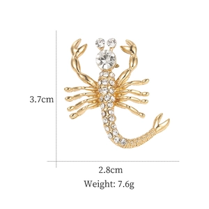 Vue détaillée d'une broche scorpion dorée avec strass indiquant les dimensions et le poids
