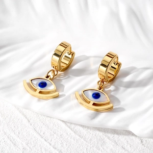 Golden stainless steel evil eye drop earrings with blue pupil on white display stand