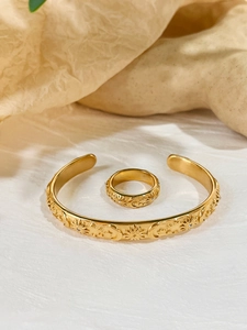 Detailed macro view of gold-plated celestial jewelry set featuring sun and moon relief