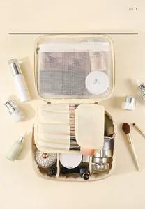 Detail of cream PU leather makeup bag showing internal compartments and brush slots