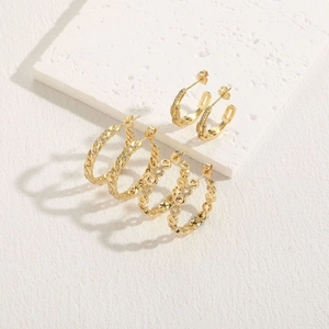 Boucles d'oreilles bohèmes plaquées or avec zircons sur présentoir géométrique