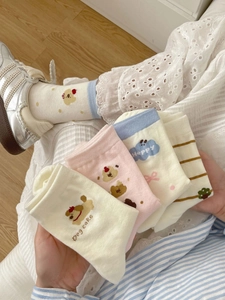 Gros plan sur cinq paires de chaussettes mignonnes en coton avec motifs chien et nuages