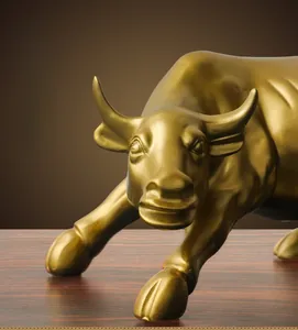 Macro side view of golden bull sculpture on wood surface with detailed muscular lines