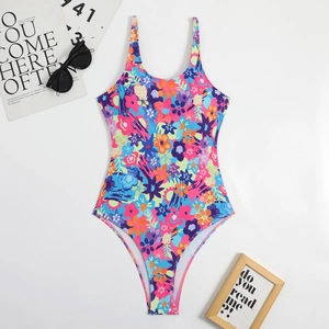Flat lay of a floral one-piece swimsuit with spaghetti straps on a white background