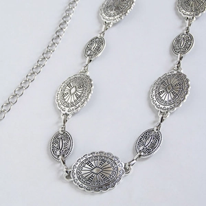Bohemian silver waist chain with vintage embossed metal discs on white background