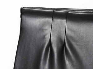 Détail de la taille plissée et des coutures fines sur le short en similicuir noir