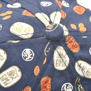 Macro shot of navy baseball cap crown featuring traditional golden fortune patterns