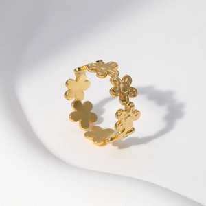 Macro detail of gold flower pattern band ring with polished daisy petal textures