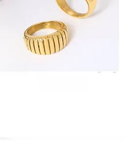 Macro detail of gold-plated croissant ring with vertical wave textures on vintage book