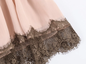 Dettaglio dell'orlo in chiffon rosa con rifiniture in pizzo marrone scuro