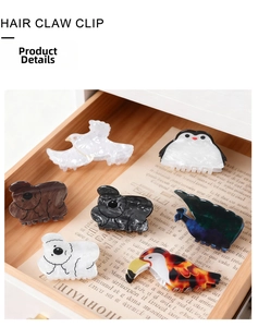 Detailaufnahme bunter Tier-Haarklammern aus Acryl in einer Holzschublade zur Anzeige