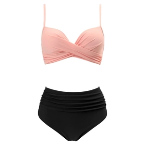 Detail of pink twist front bikini top and black high-waisted ruched bottoms on white background