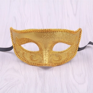 Close-up of golden Halloween masquerade mask with glitter scroll patterns and woven lace edges