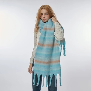 Soft striped tassel scarf in blue and orange gradient worn by a model in studio