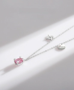 Close-up of S925 silver necklace featuring a pink teardrop zircon and engraved charms
