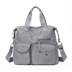 Detail of grey Oxford travel bag showing multi-pocket design and adjustable shoulder strap
