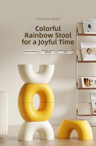 Close-up of stackable rainbow-shaped Nordic plastic stools in warm yellow and ivory