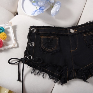 Dettaglio di pantaloncini di jeans neri con lacci laterali e orlo grezzo sfilacciato