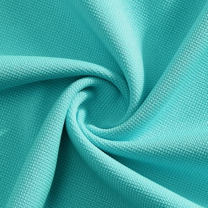 Close-up of teal pique knit fabric showing breathable mesh texture for polo shirts