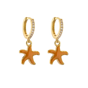 Detailed close-up of gold starfish drop earrings with zircon inlay and orange glaze