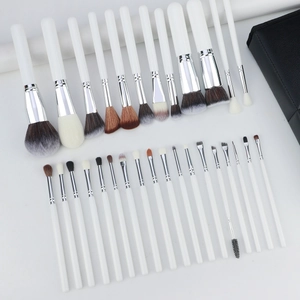 Detailed flat lay of 30 professional makeup brushes with white handles and storage bag