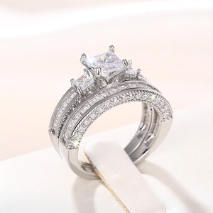 Macro-detail van de zilveren ringenset met princess-slijpvorm en milgrain pavé