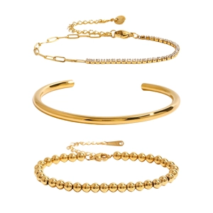 Ensemble de trois bracelets en acier titane doré comprenant chaîne, jonc et perles