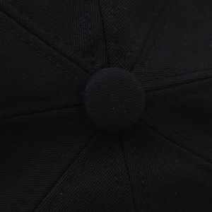 Close-up of black twill octagonal hat crown showing precise stitching and top button detail