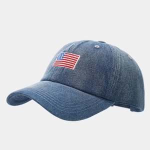Macro view of detailed American flag embroidery on dark blue denim baseball cap surface