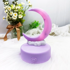Detailed close-up of a purple crescent moon night light with heart button and cloud base
