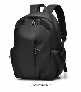 Detail view of the black nylon backpack showing padded shoulder straps and multiple zippers