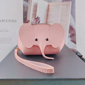 Detailed close-up of pink leather elephant coin purse with litchi grain texture