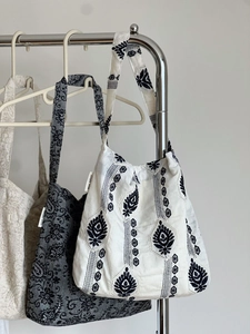 Broderie détaillée et étiquette de marque sur des sacs à bandoulière en coton
