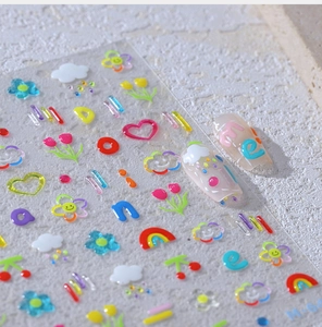 Macro detail of embossed cute nail art stickers with rainbow and flower patterns
