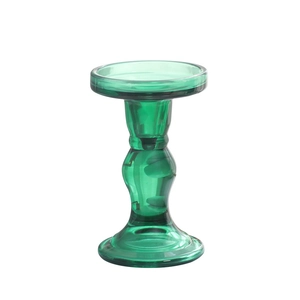 Vintage green glass candle holder with elegant curved body and a wide base on white background