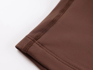 Macro shot of dark brown high-elastic seamless fabric with professional stitching detail