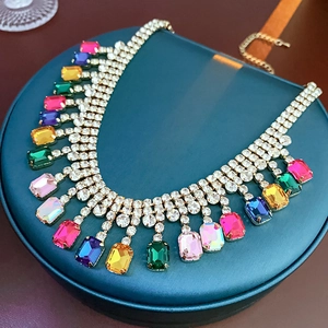 Détail du collier doré avec cristaux rectangulaires colorés et pampilles en strass