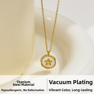 Detail of 18k gold plated titanium steel star pendant on a white ceramic cup