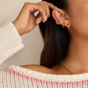 Détails des boucles d'oreilles soleil en or 18 carats et strass sur un mannequin