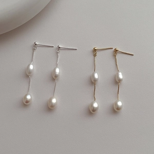 Detail of long tassel earrings with two teardrop freshwater pearls in gold and silver finish