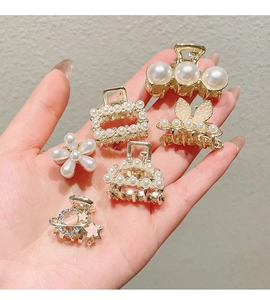 Detailed set of six gold metal hair claws with white pearls in various delicate shapes