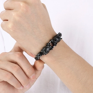 Close-up of men's black titanium steel wolf head bracelet with intricate chain link texture