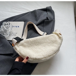 Detail of soft cream white fleece chest bag with wide strap on a textured blazer