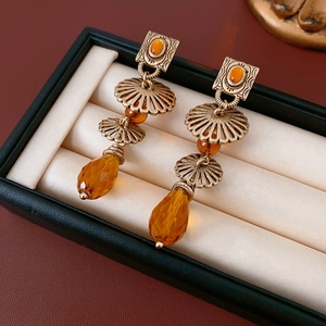 Vintage bronze drop earrings with amber gemstone detail on a jewelry display