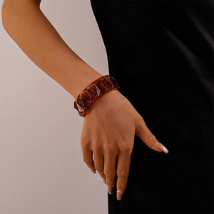 Macro detail of amber resin geometric cuff bracelet showing faceted design and transparency